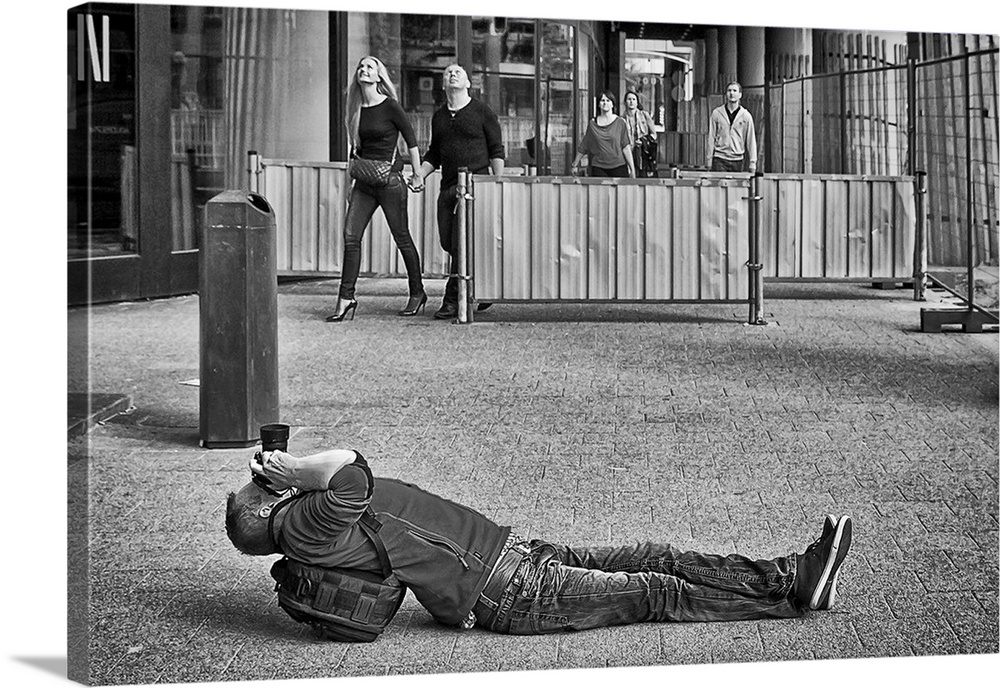 Photographer laying on his back in the street to get a good angle, Rotterdam, Netherlands.