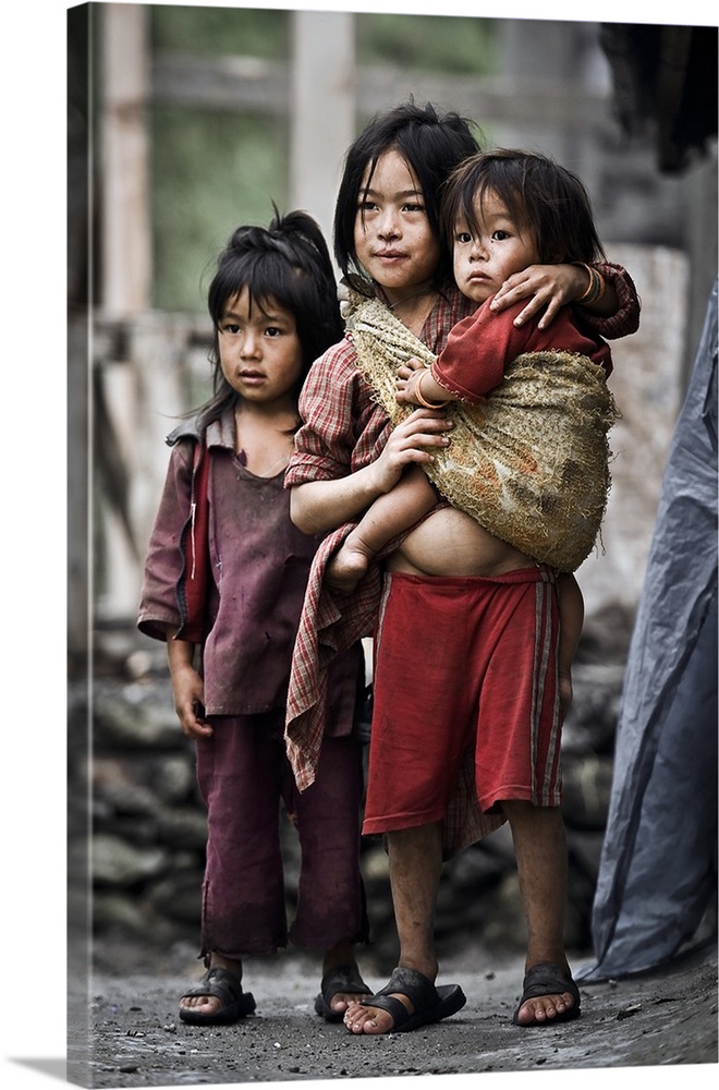 Three young children standing in the streets in the Himalayas, Nepal.