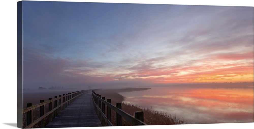 Pastel sunlight on clouds at dawn over a bridge in Denmark.
