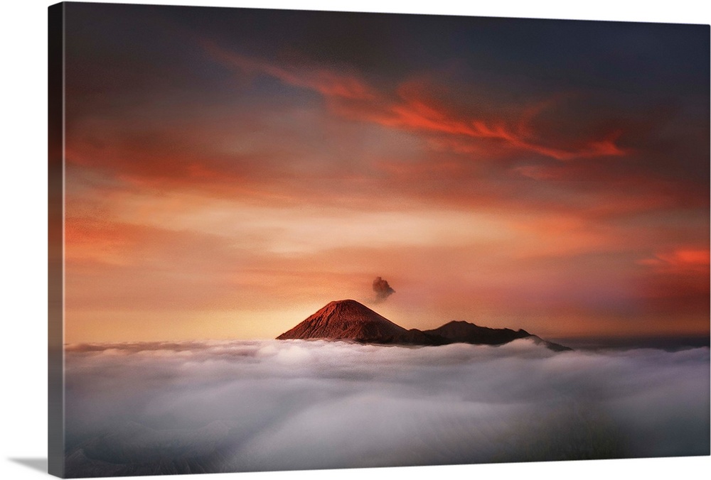 The peaks of Mahameru in Indonesia at sunset, visible over the clouds.