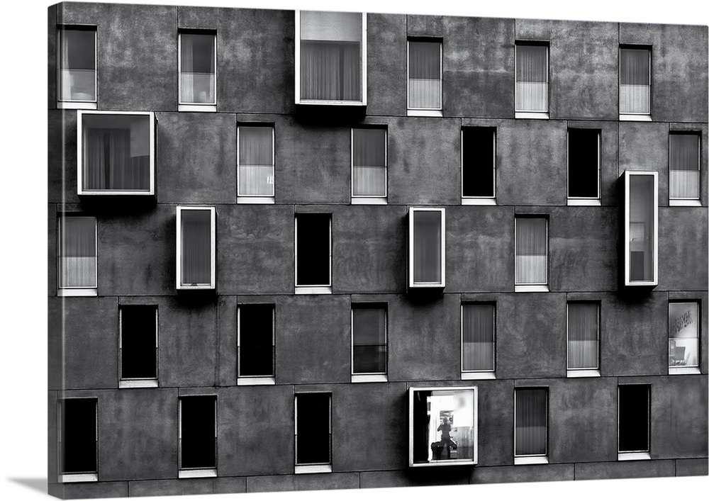 Facade of an apartment building with windows forming a repeating pattern.