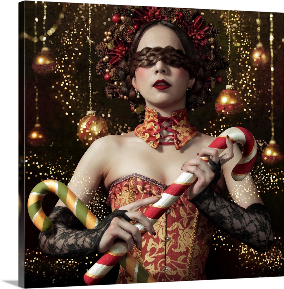Conceptual image of a woman in a corset and elaborate hairstyle holding candy canes in front of hanging tree ornaments.