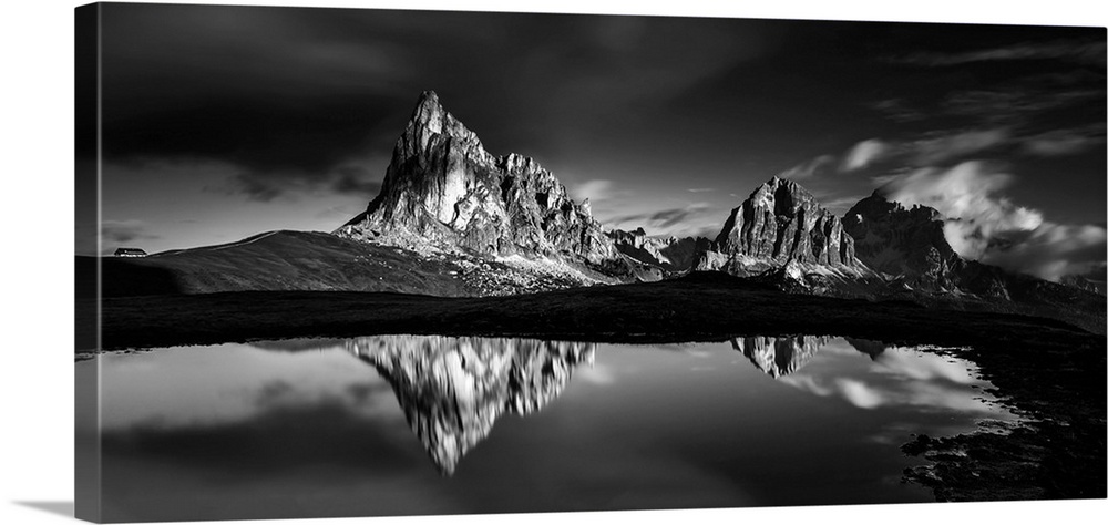 Black and white panoramic landscape photograph of the Dolomites, Italy with reflections on the lake.