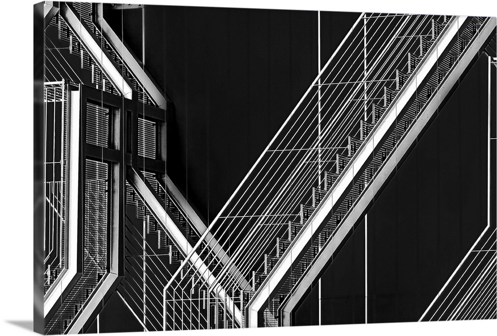 High contrast black and white image of an outdoor staircase against the dark facade of a building.
