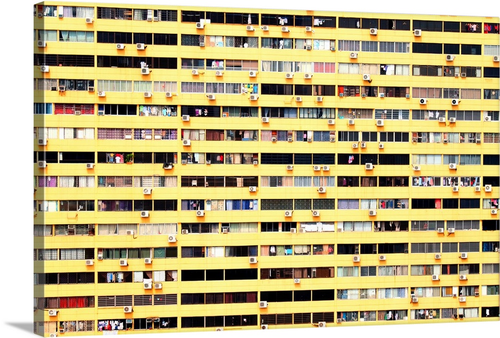 Facade of a yellow building with a variety of window decor and styles, alluding to the separate lives of the residents ins...