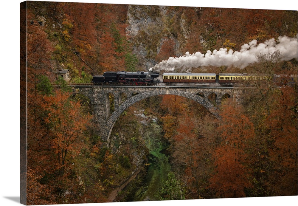 Old museum train is passing a bridge in Vintgar Gorge in autumn season
