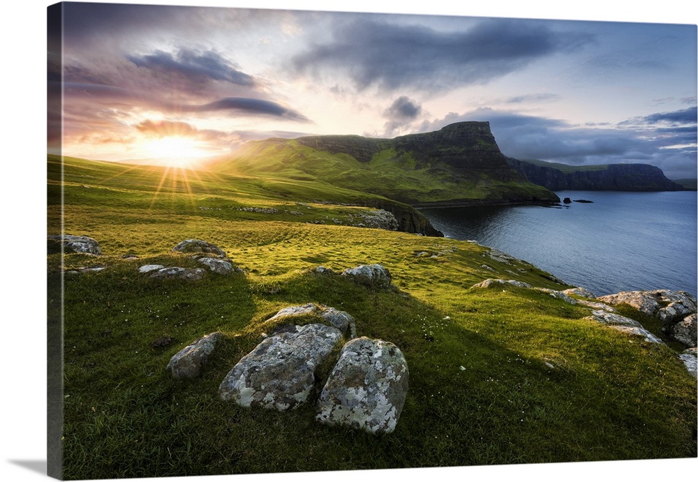 A fine art photograph of a remote coastline in Scotland with the sun setting over the hills