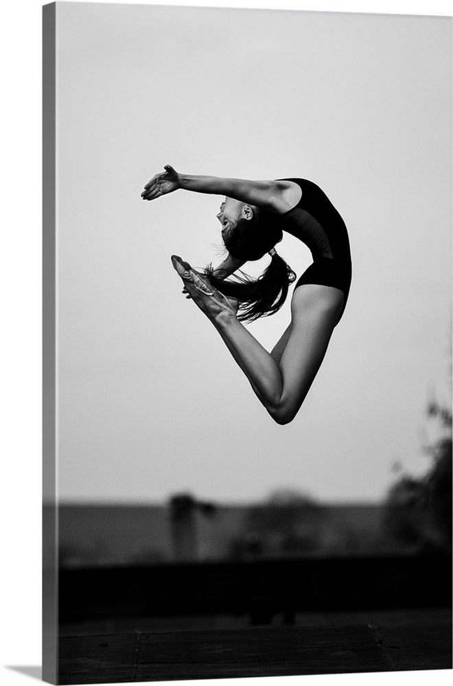 A dancer leaping into the air, arching her back.