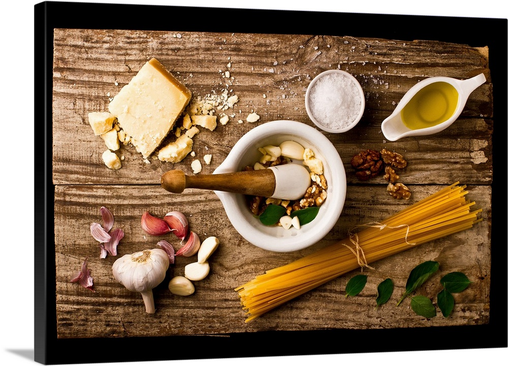 Spread of ingredients for pesto arranged on a wooden board and in a mortar and pestle.
