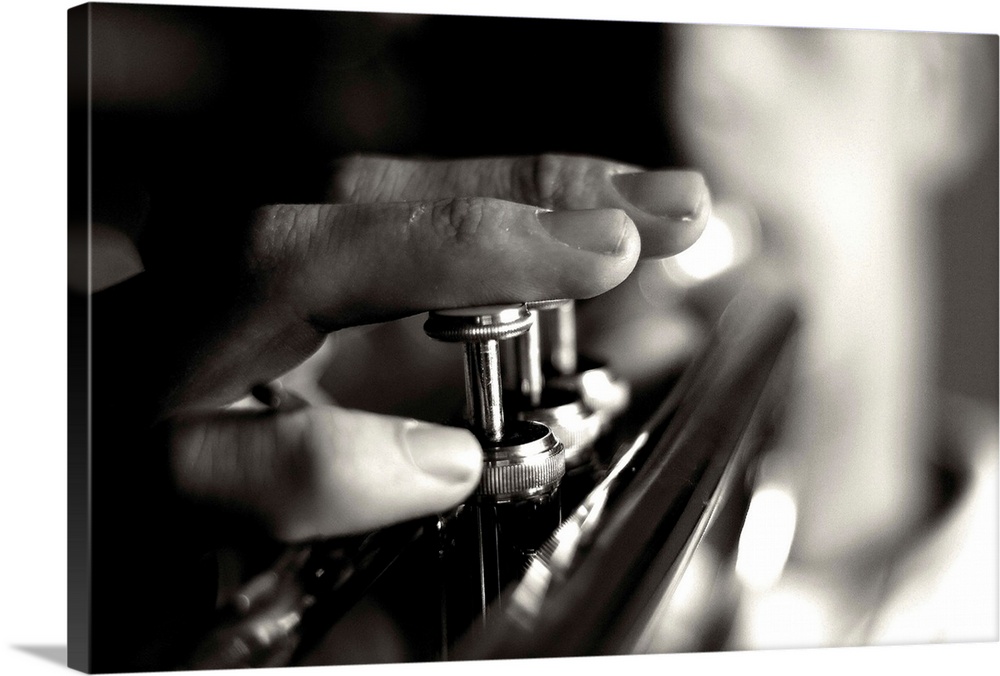 Close up image of a person playing the trumpet, focusing on the fingers and buttons.