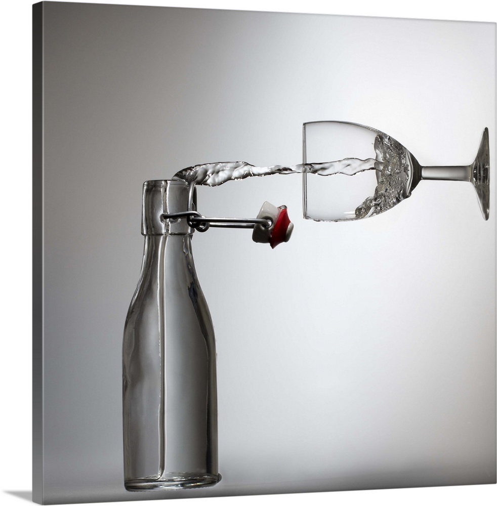 Conceptual image of water being poured from a bottle into a glass, appearing sideways.