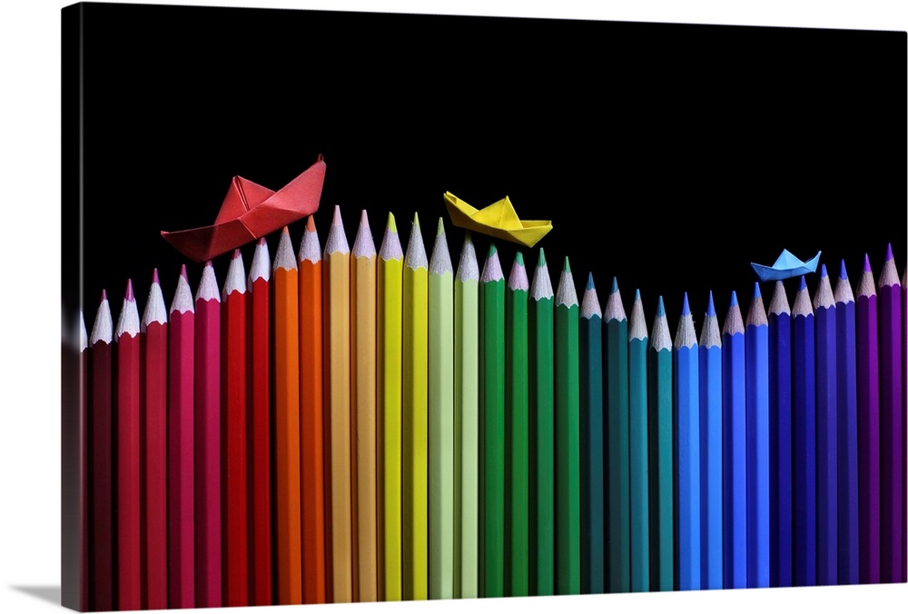Little origami boats sailing on waves of colored pencils.