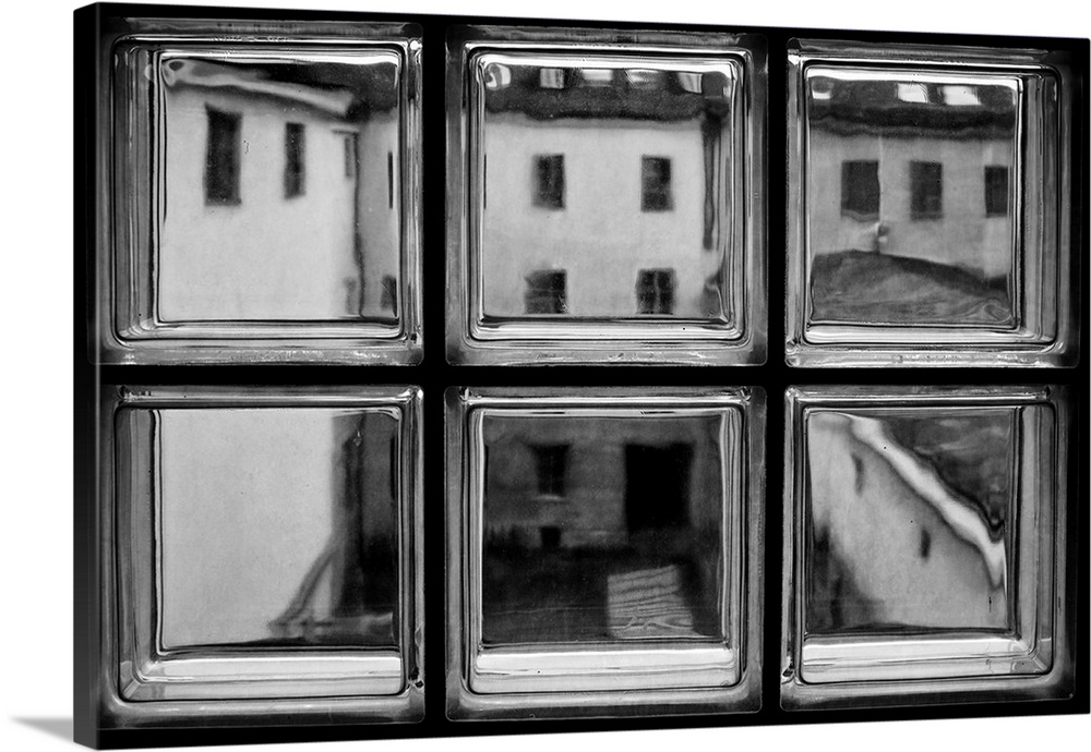 A window made of six glass squares, looking out into an alley.