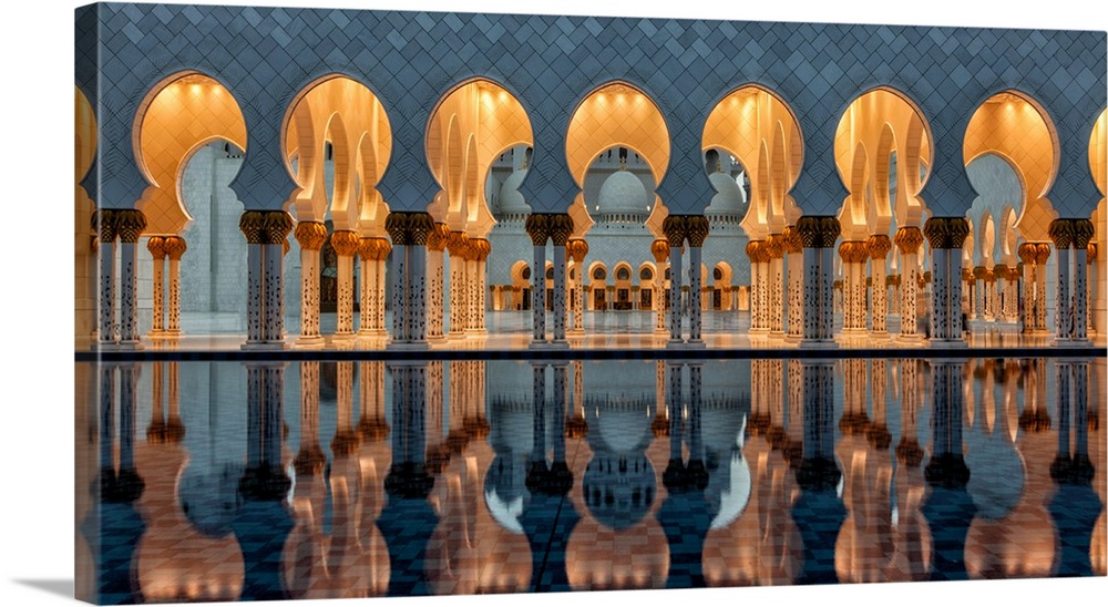 Arches and columns of the Sheikh Zayed Grand Mosque in Abu Dhabi reflected in the pool.