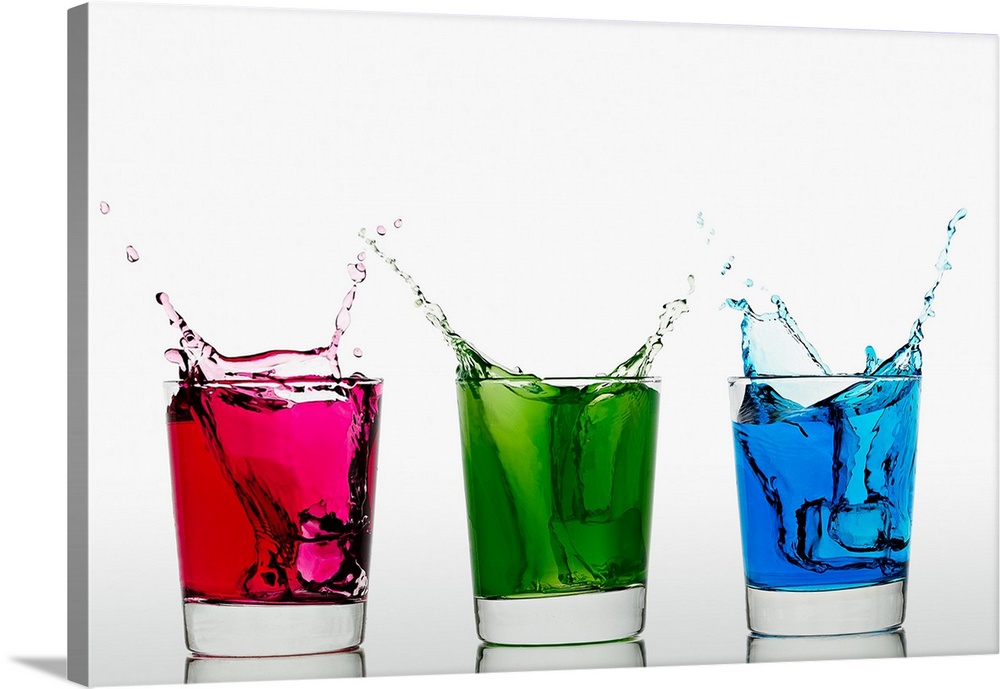 Ice cubes falling into three glasses with different colored liquid