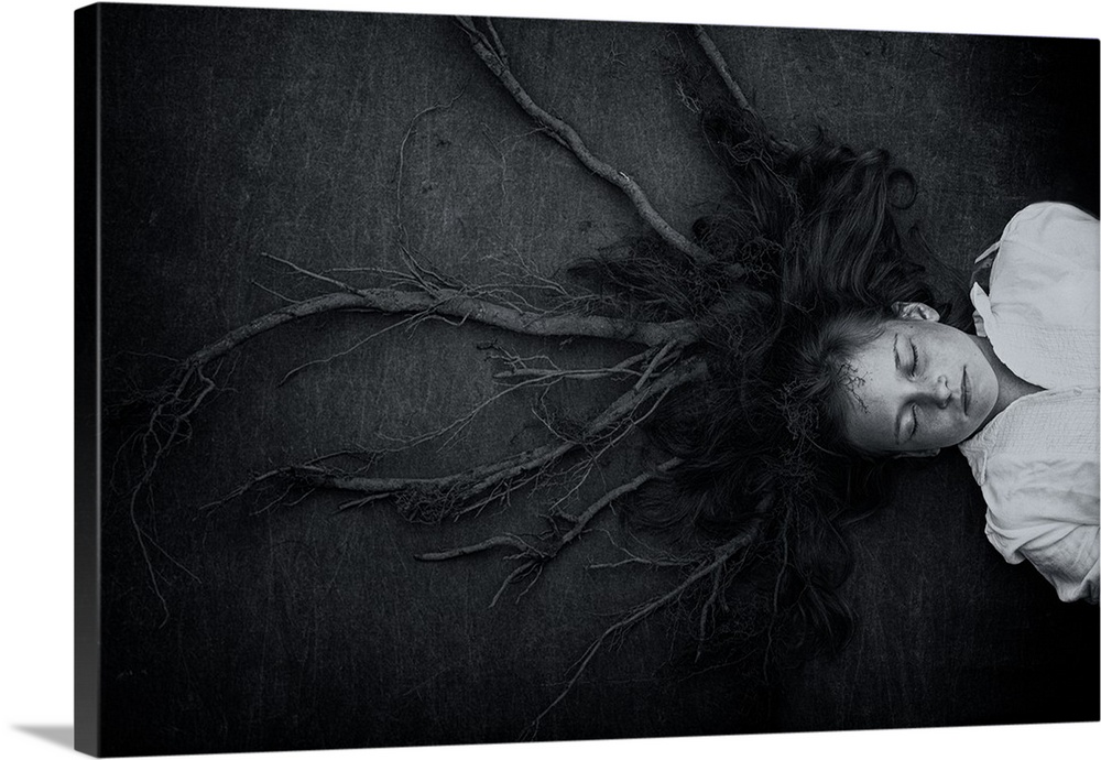 Conceptual image of a young girl laying on the ground, with her hair transforming into roots.