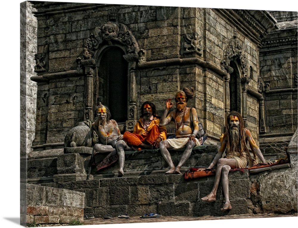 A group of men with bodypaint sitting at a temple during a festival.