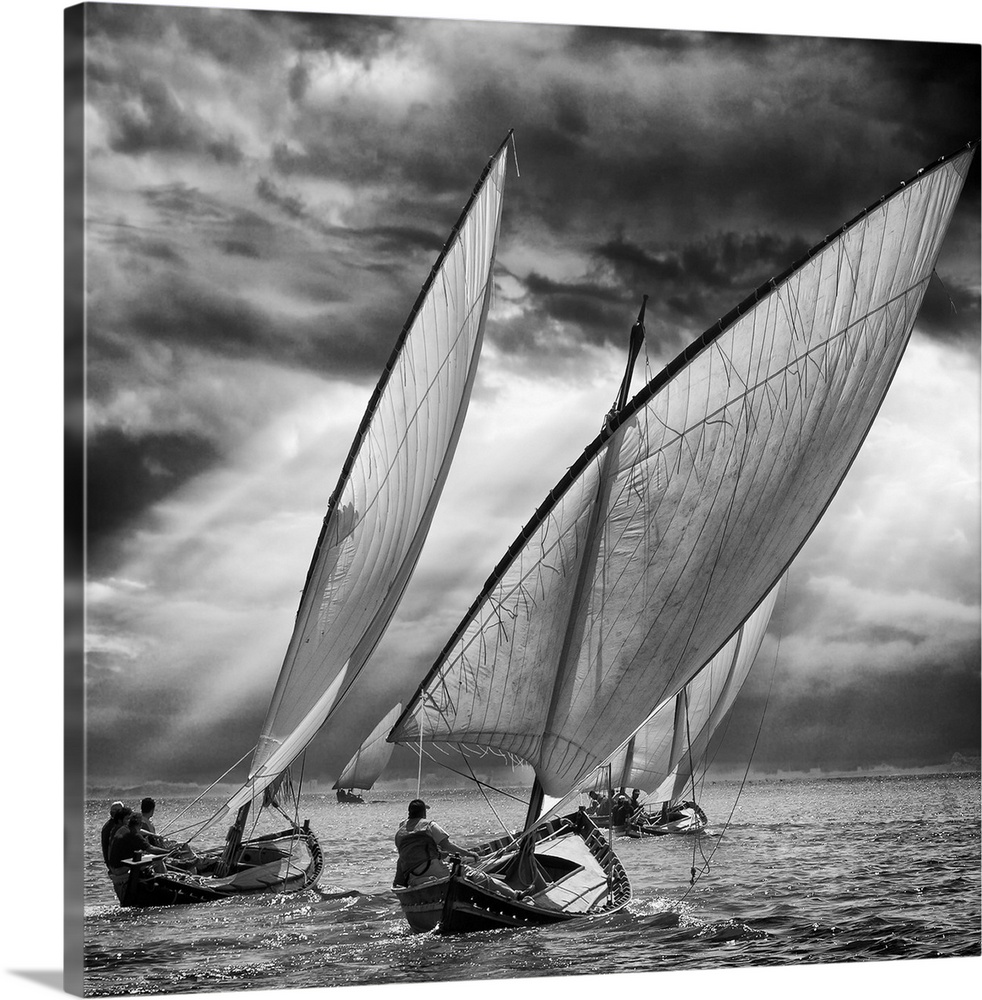 Black and white image of a fleet of sailboats leaning in the wind under stormy skies.