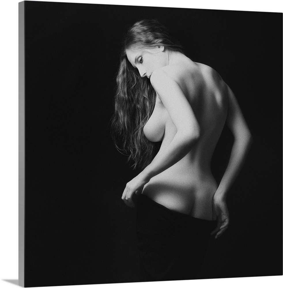 A black and white portrait of nude woman from behind partially exposed.