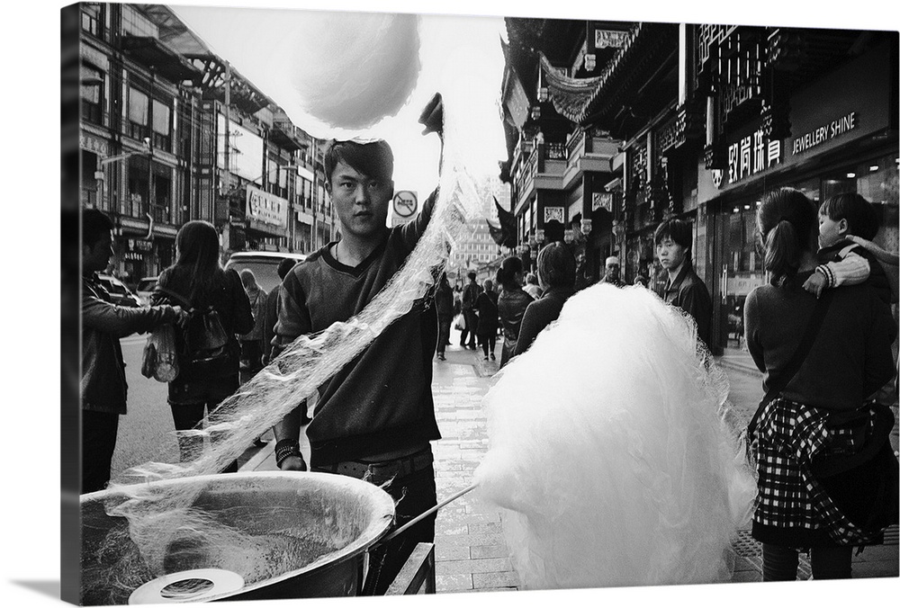 Man twirling cotton candy onto a stock in the streets of Shanghai, China.