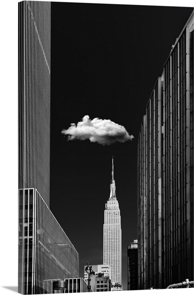 Black and white photograph of a New York City cityscape highlighting the single cloud hanging over the Empire State Building.