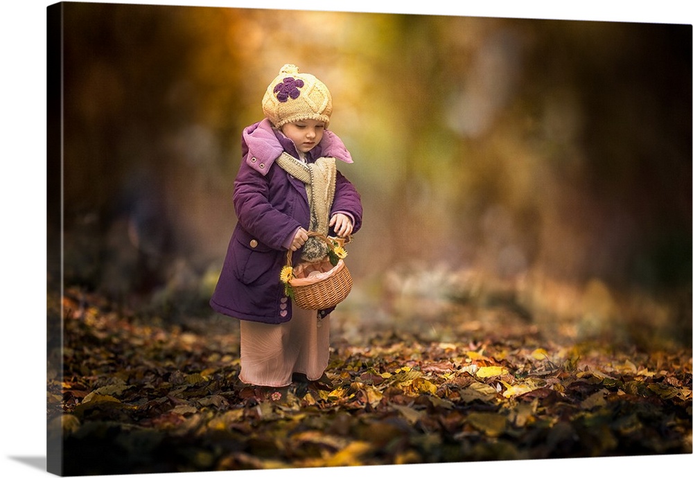 A little girl in a big coat holding a basket in the fall.