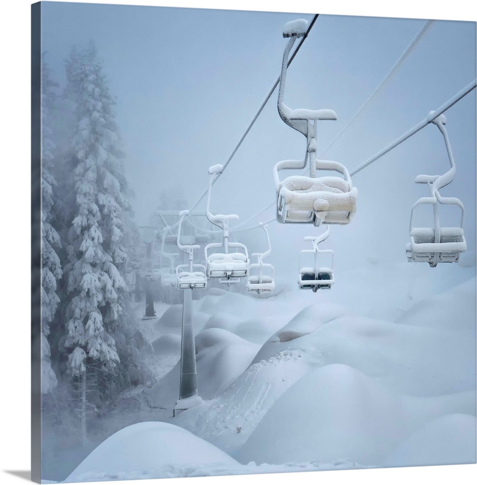 A ski lift and surrounding landscape covered in snow.