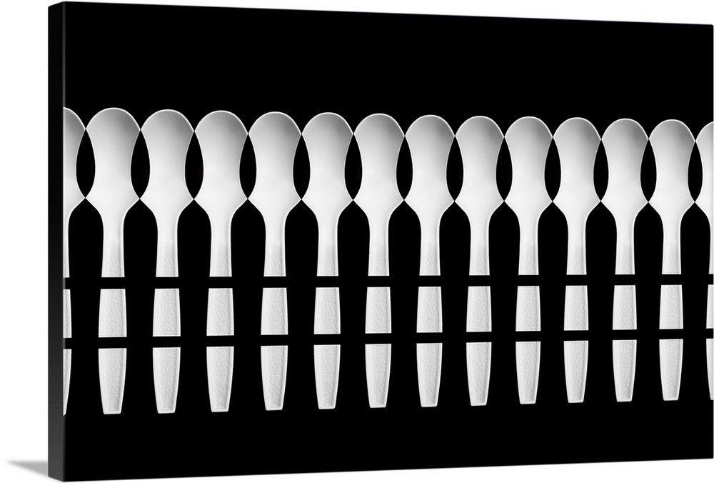 An abstract pattern created by a multitude of white plastic spoons.