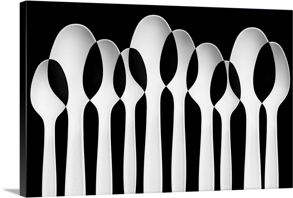 Spoons standing in a row, with negative space where they intersect.