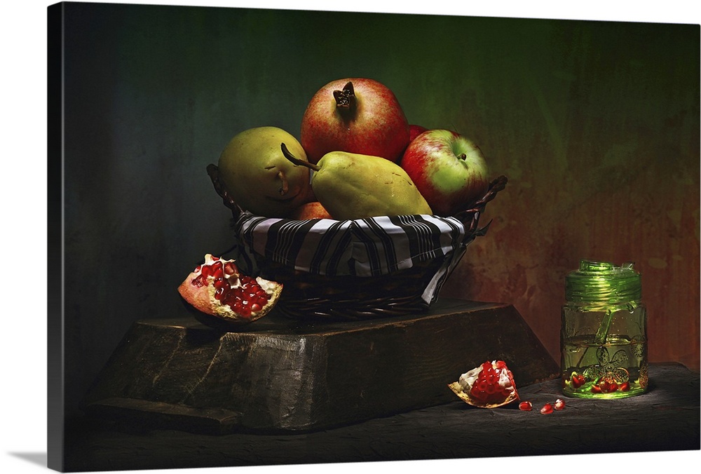 Still life photo of a basket of fruit, including pears and pomegranates.