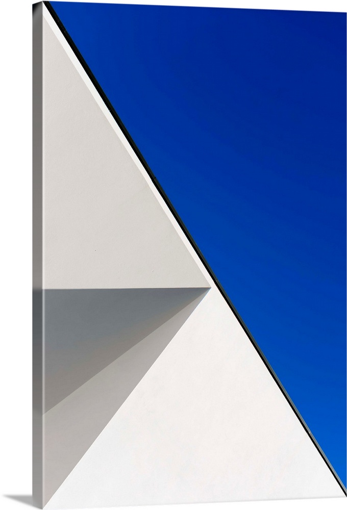 Side of a white building against a blue sky, creating an astract geometric image.