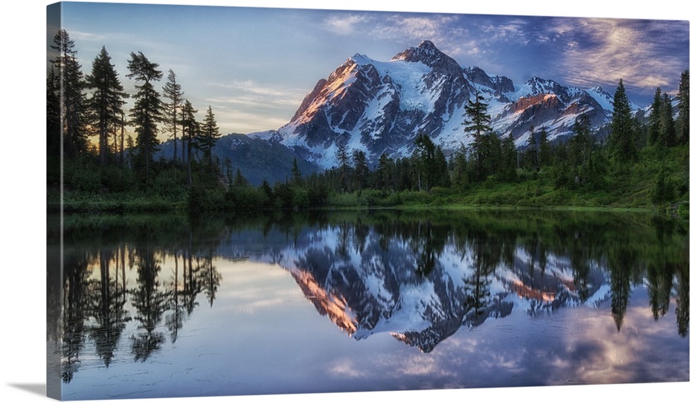 Mount Shuksan in Washington mirrored in the lake below at dawn.