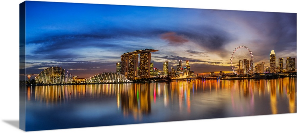 Panoramic view of the bay in Singapore, glowing at night with lights from the city.