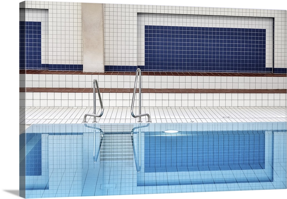 Perfectly still water in an indoor pool, with tiled walls and floors.