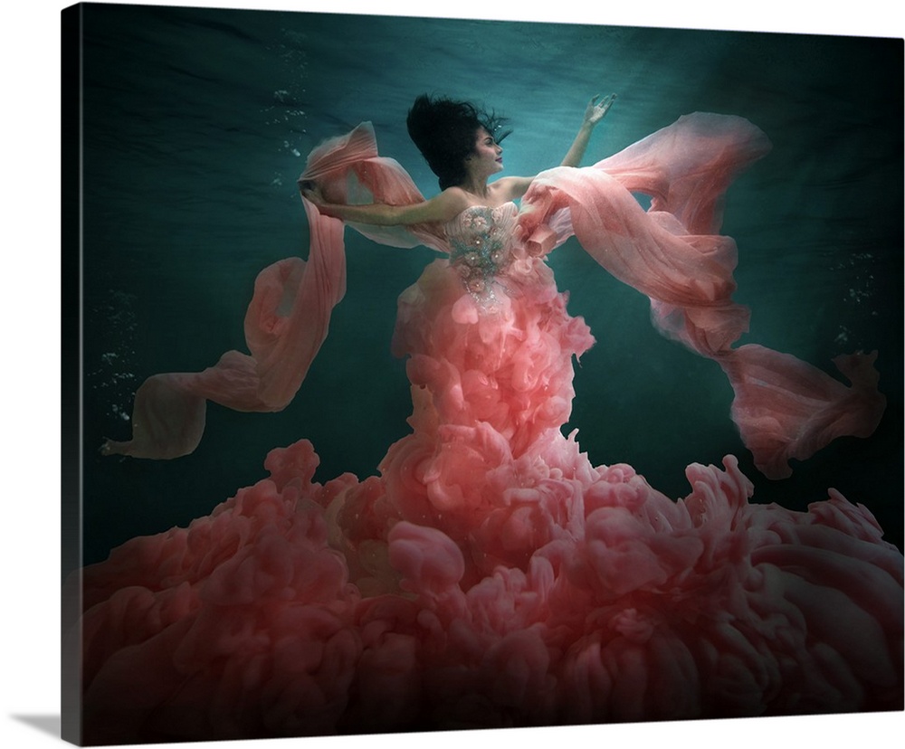 Underwater photo of a woman wearing a billowing pink dress.