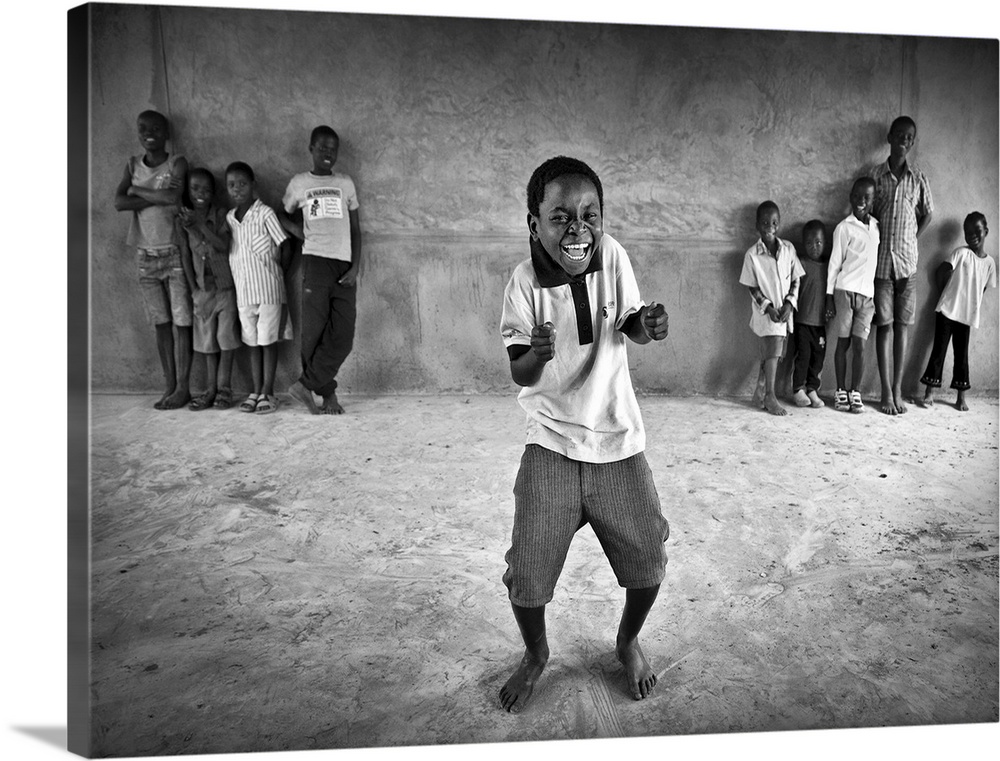 Portrait of a little boy dancing and have a laugh while other children watch him.