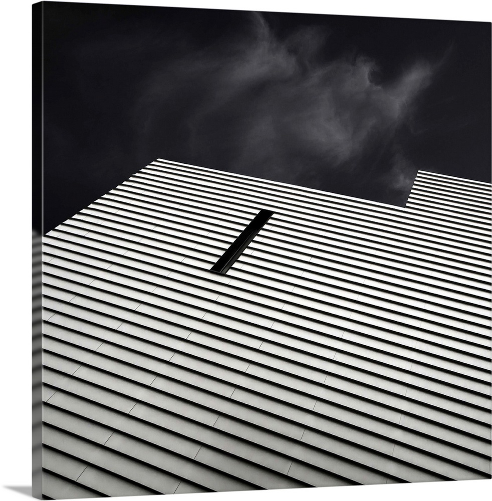 A narrow window breaks the horizontal striped pattern on the side of a building.