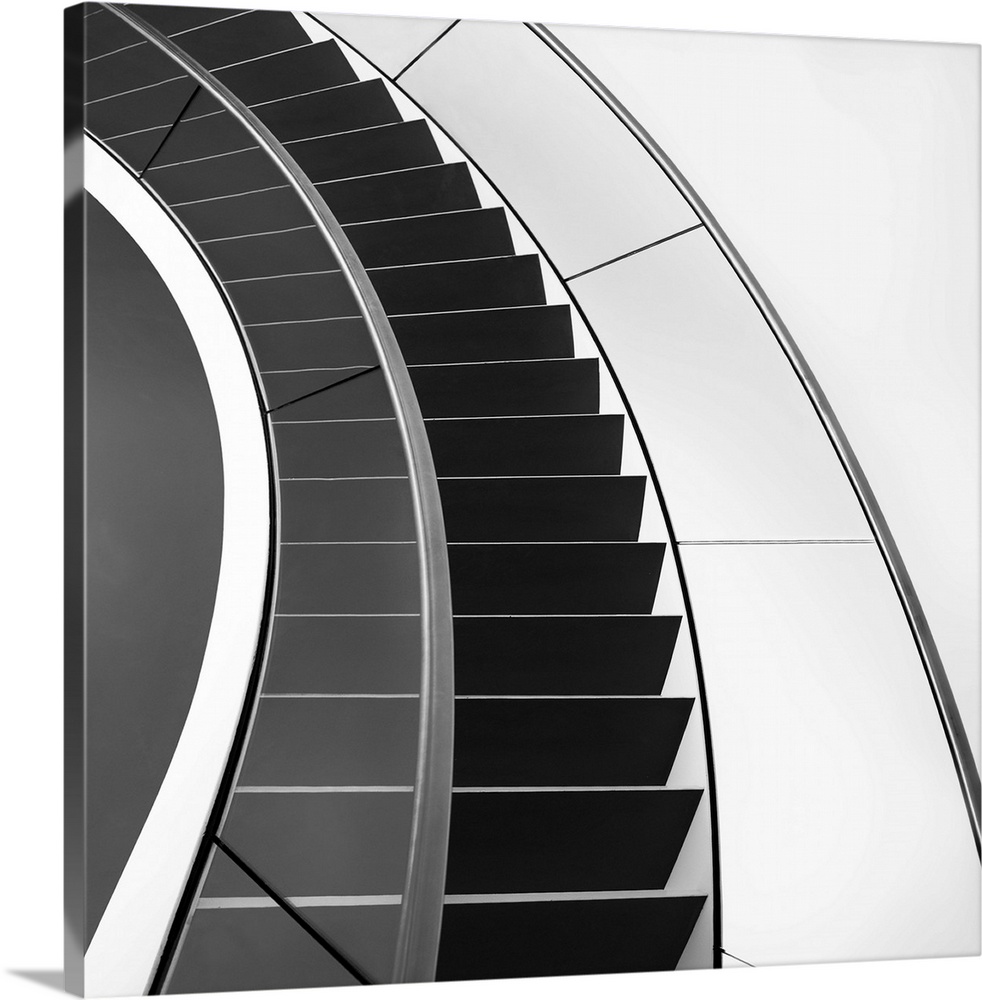 Black and white image of a staircase curving around.