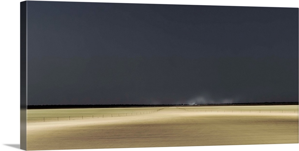 Calm landscape in Namibia of yellow plains under a dark sky.