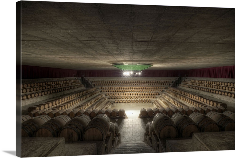 Inside a Tuscan wine cellar looking down into a pit-like arena surrounded by casks of wine, Italy.