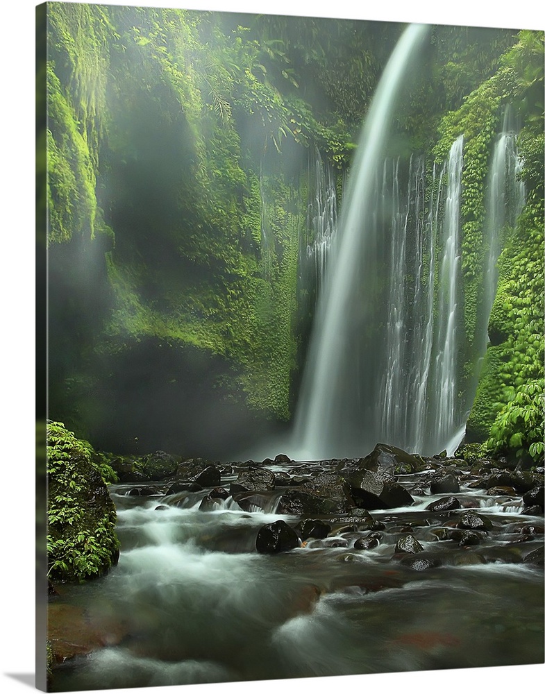 A majestic waterfall in a cliff covered in lush vegetation, Indonesia.