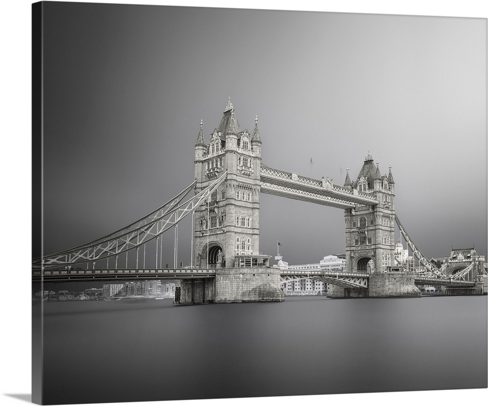 Black and white photograph of Tower Bridge in London with silky, calm water below.