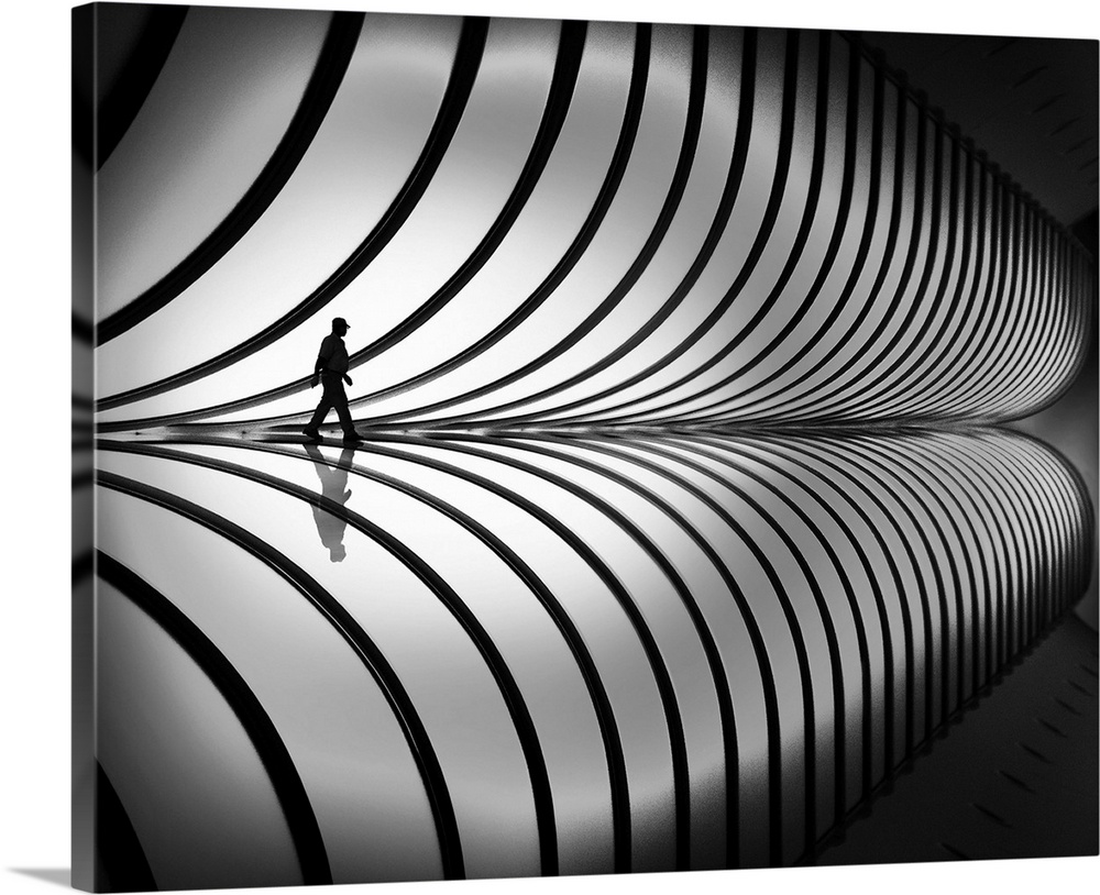 A person walking past a striped, curved wall, with a mirror reflection below.