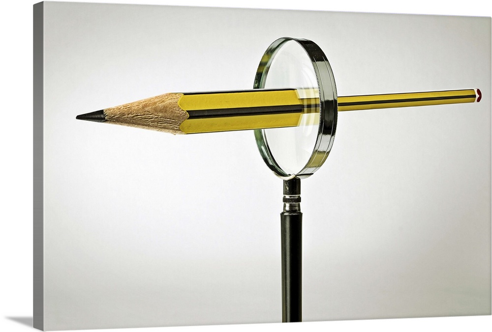 Conceptual image of a pencil passing through a magnifying glass, emerging bigger on the other side.