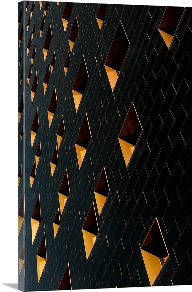 Architectural abstract photograph of a building facade with black rectangular tiles and yellow window.