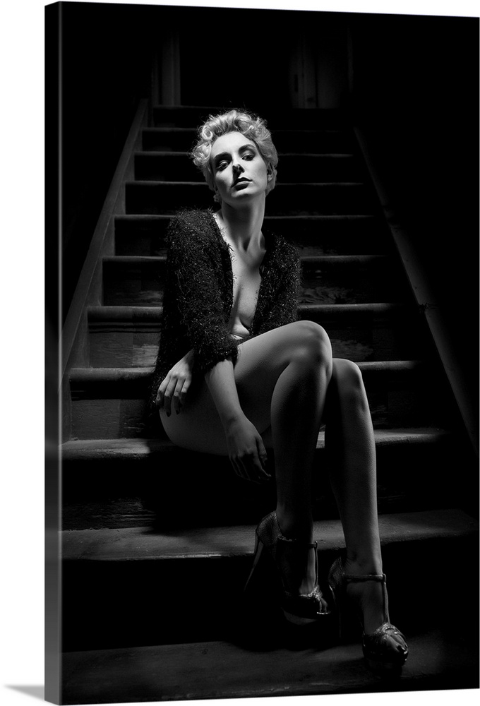 A portrait of beautiful woman in lingerie sitting on a steps of a staircase.