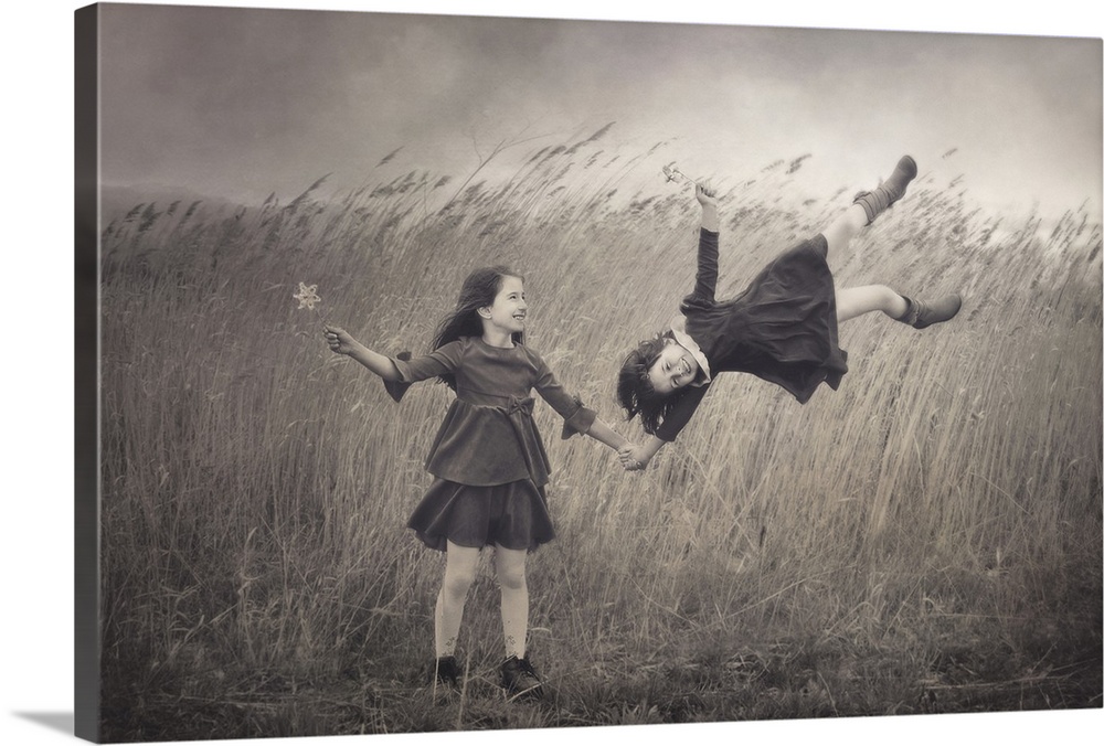Conceptual image of two little girls appearing to be blown away in the wind.