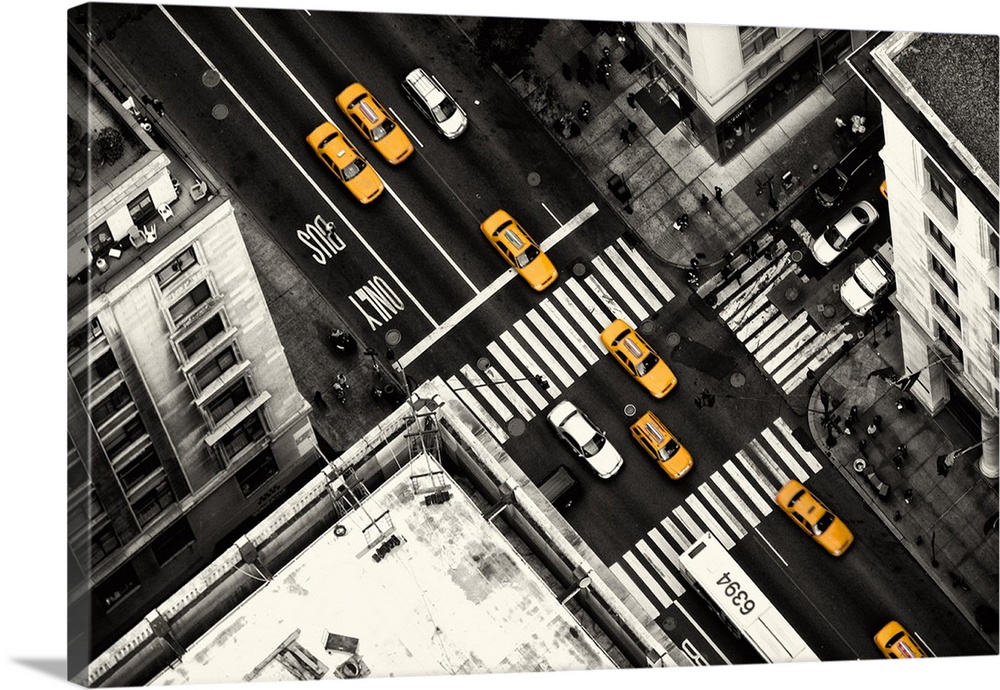 Aerial view of a Manhattan street with yellow taxi cabs standing out against the dark grey road.