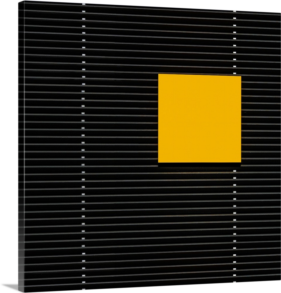A yellow square panel standing out against the horizontal lines of a building.