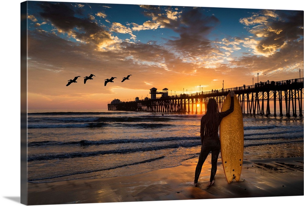Woman surfer silhouetted at Oceanside Pier. The surf next to the Oceanside pier is a favorite surfing location. Oceanside ...